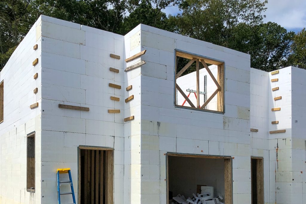Two-storey Boulder Farms townhome under construction with Amvic™ ICF walls, window openings, and garage openings.