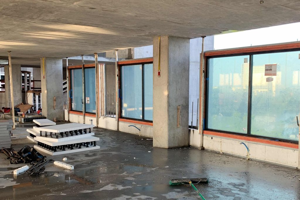 Interior construction view of the Drury Plaza Hotel tower with concrete floors, columns, and exterior window openings
